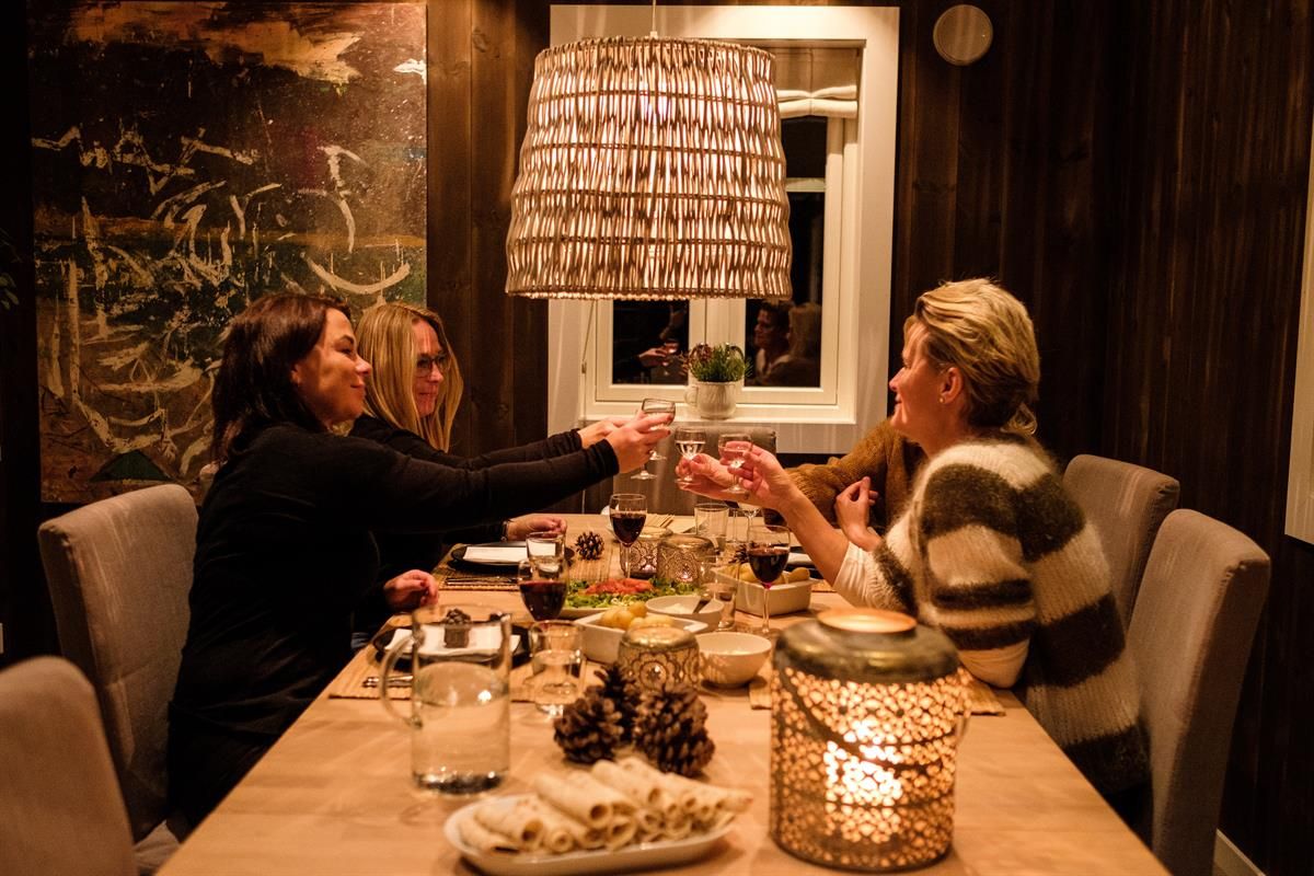 People seated around a dining table in a warmly lit room.