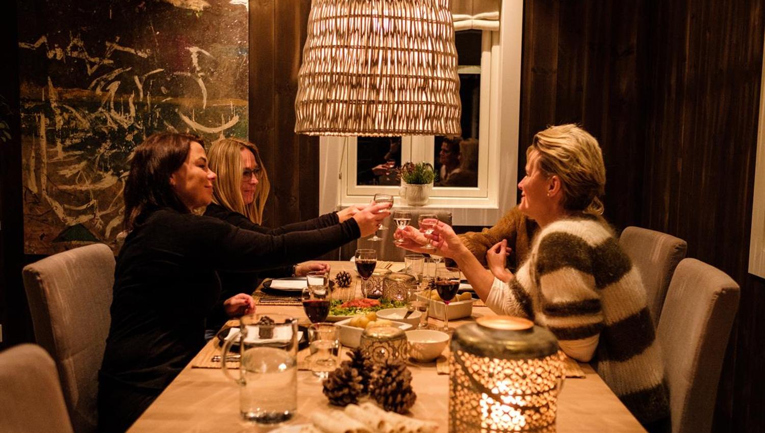 People seated around a dining table in a warmly lit room.