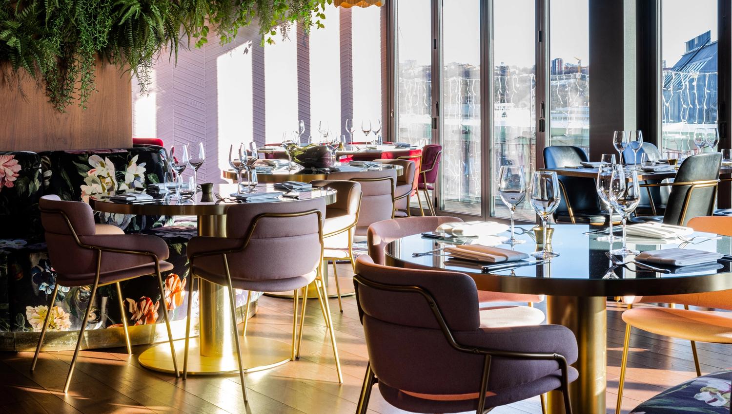 Round small tables with chairs in front of large panoramic windows
