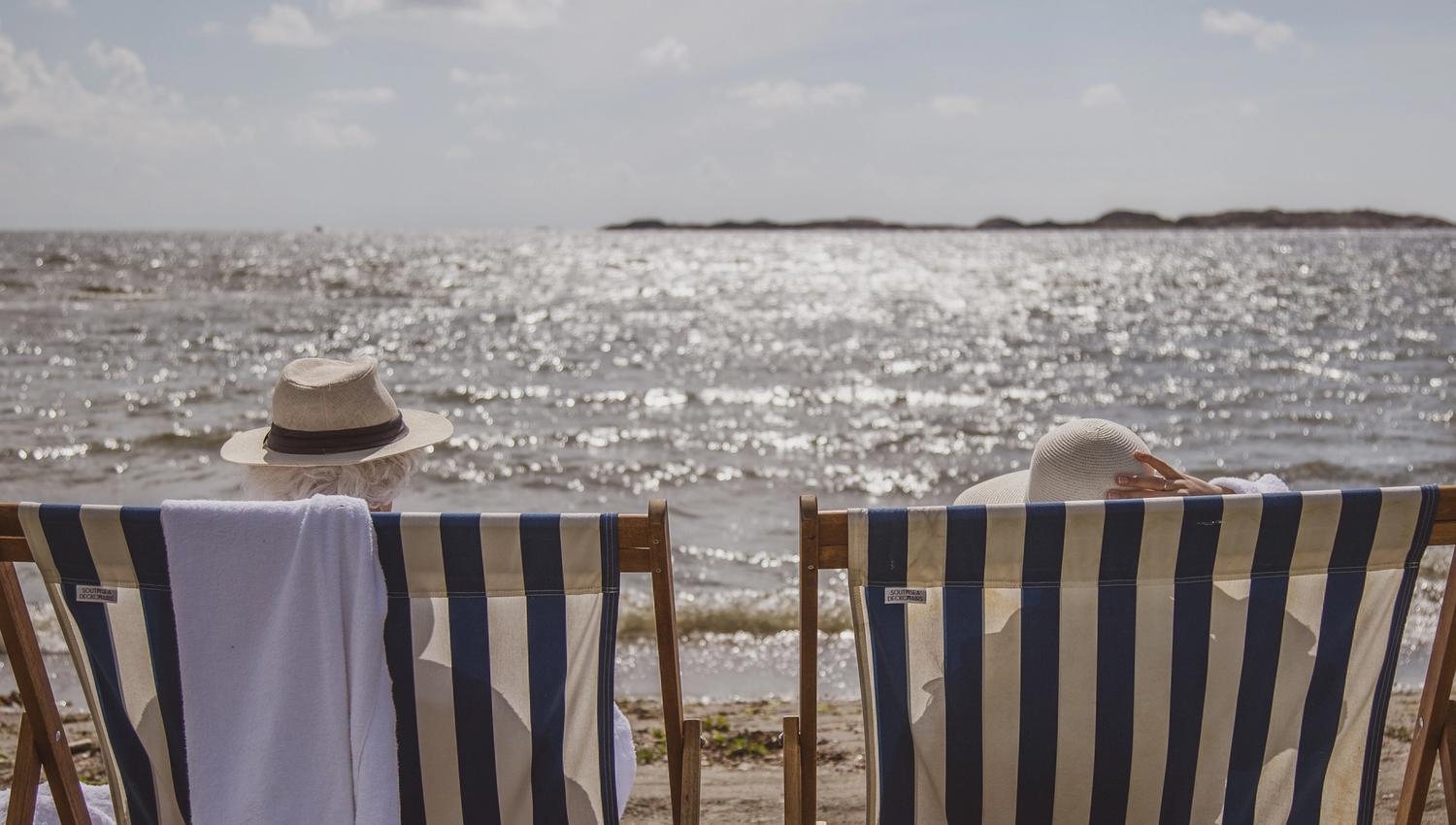 to personer sitter i solstol på strand