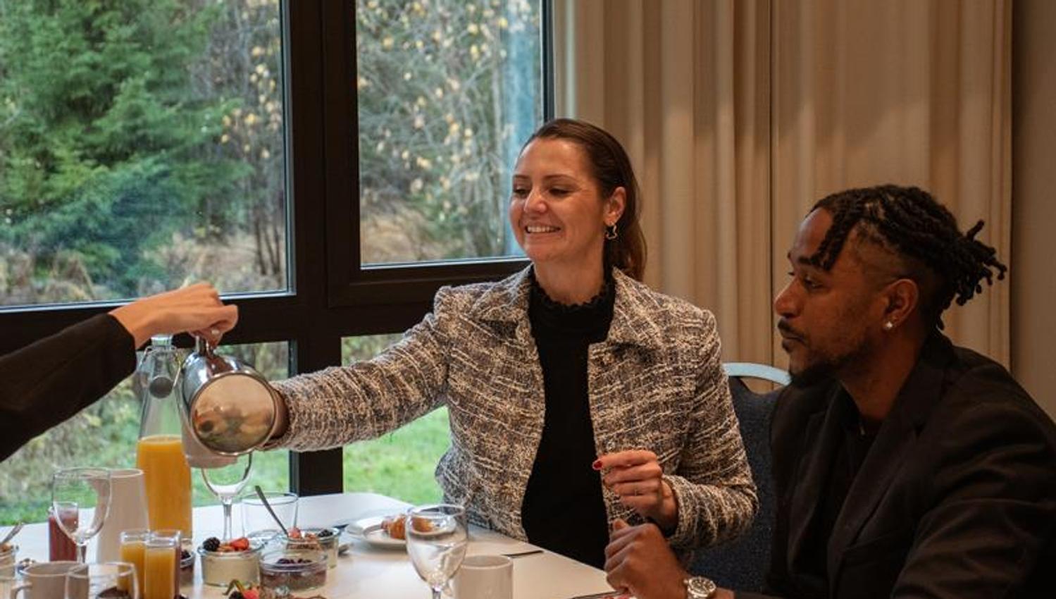 to personer sitter ved et dekket bord og nyter et mÄltid i en hyggelig restaurant