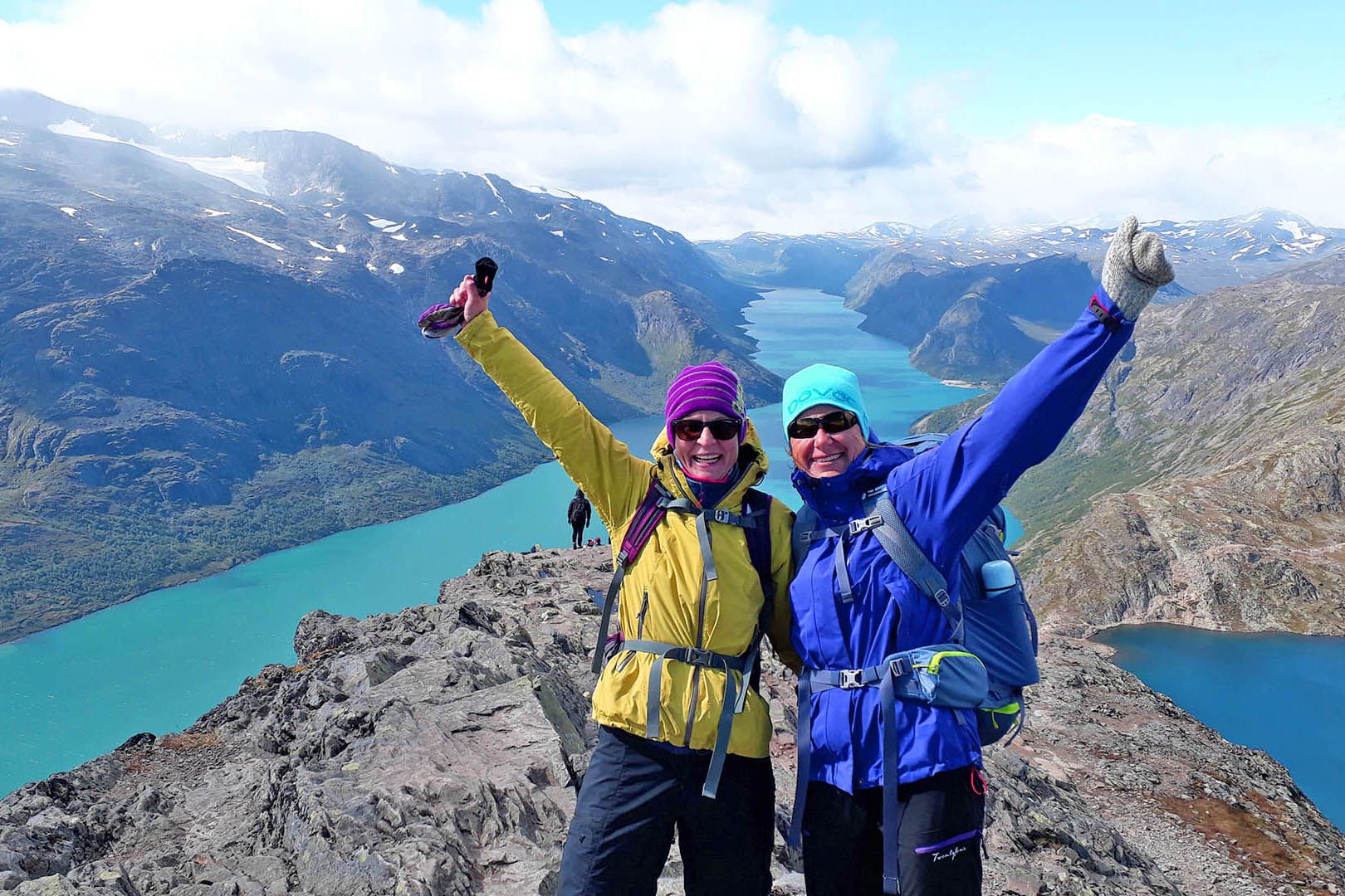 Two happy hikers on a ridge with great mountain views and lakes