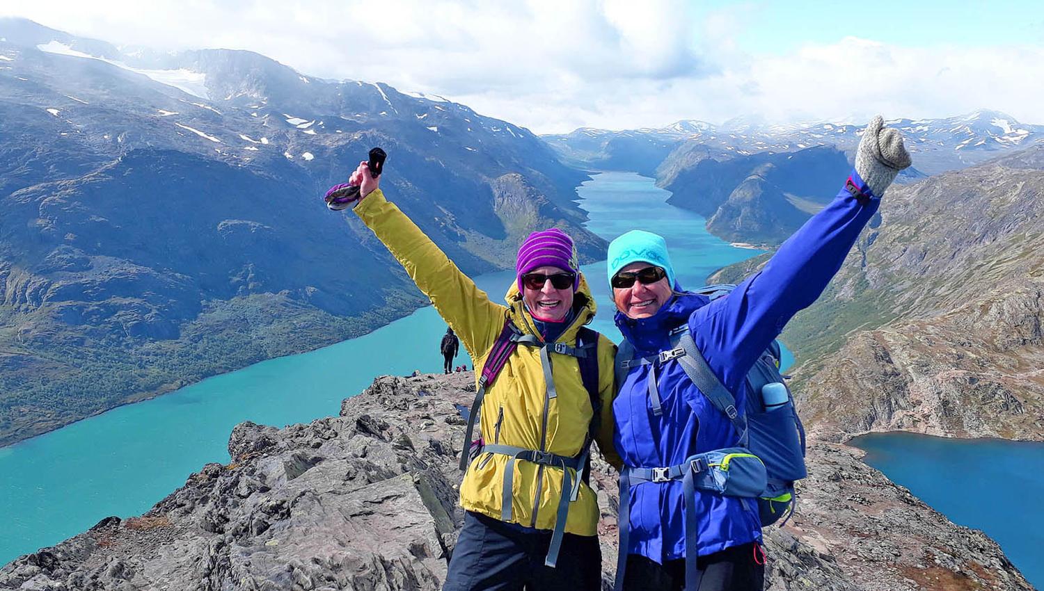Two happy hikers on a ridge with great mountain views and lakes