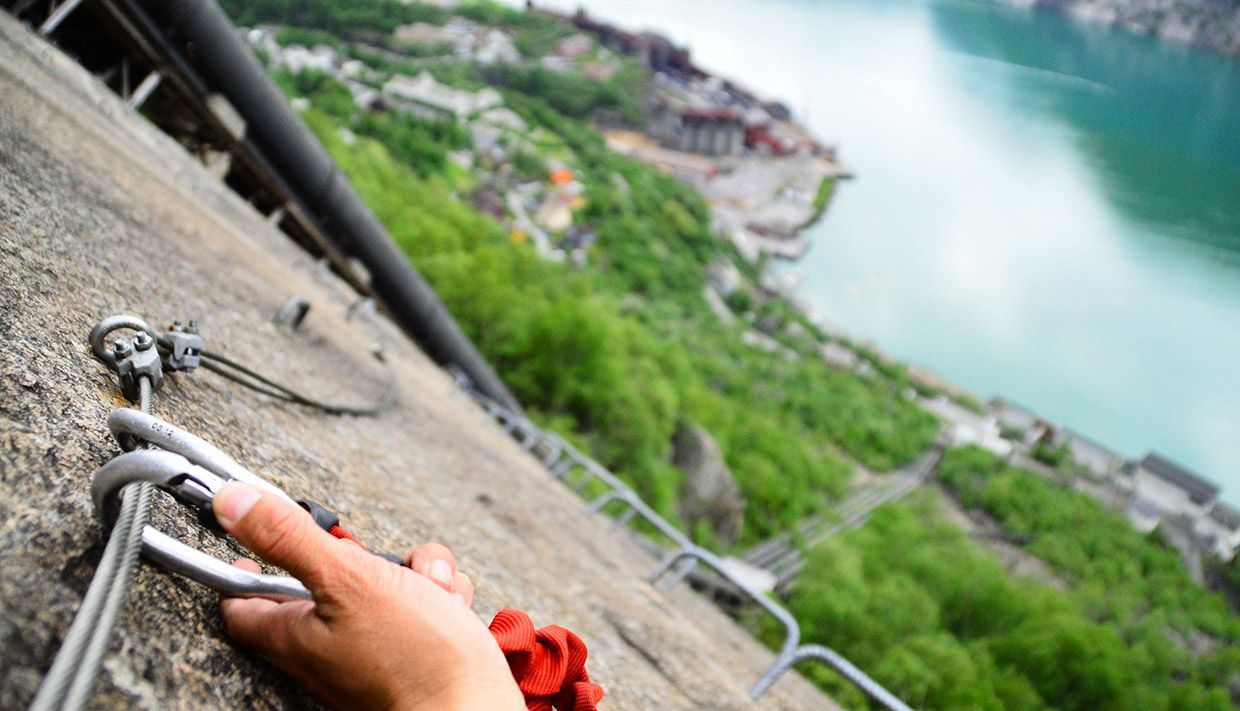 Hand attaching carabiner to the safety cable on Via Ferrata Tyssedal.