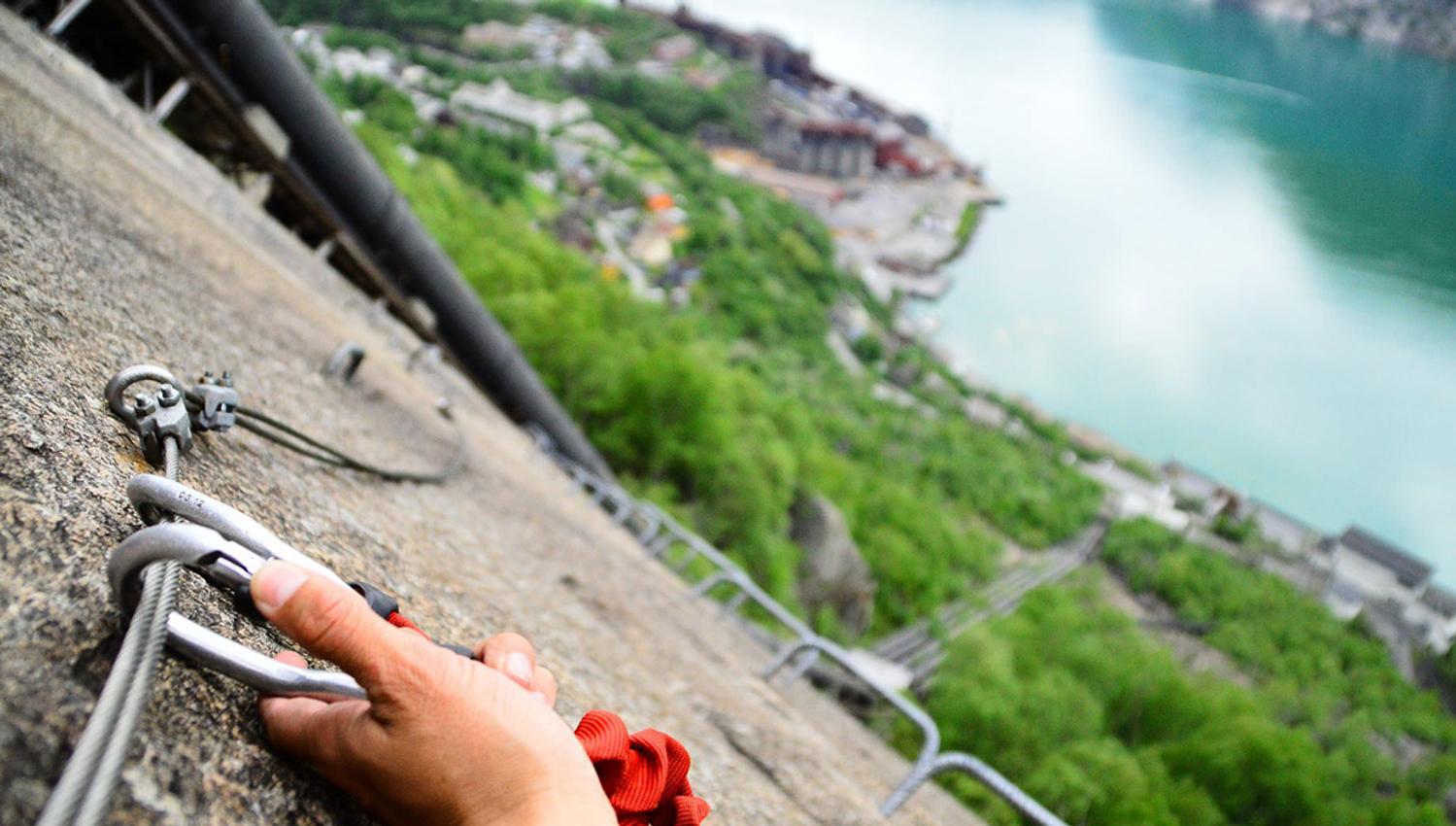 Hand attaching carabiner to the safety cable on Via Ferrata Tyssedal.
