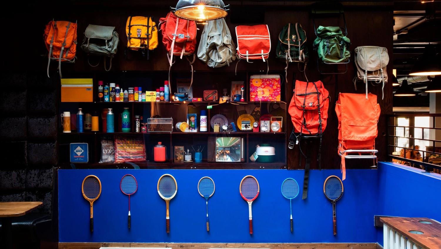 Details: various backpacks on the wall, tennis equipment and miscellaneous