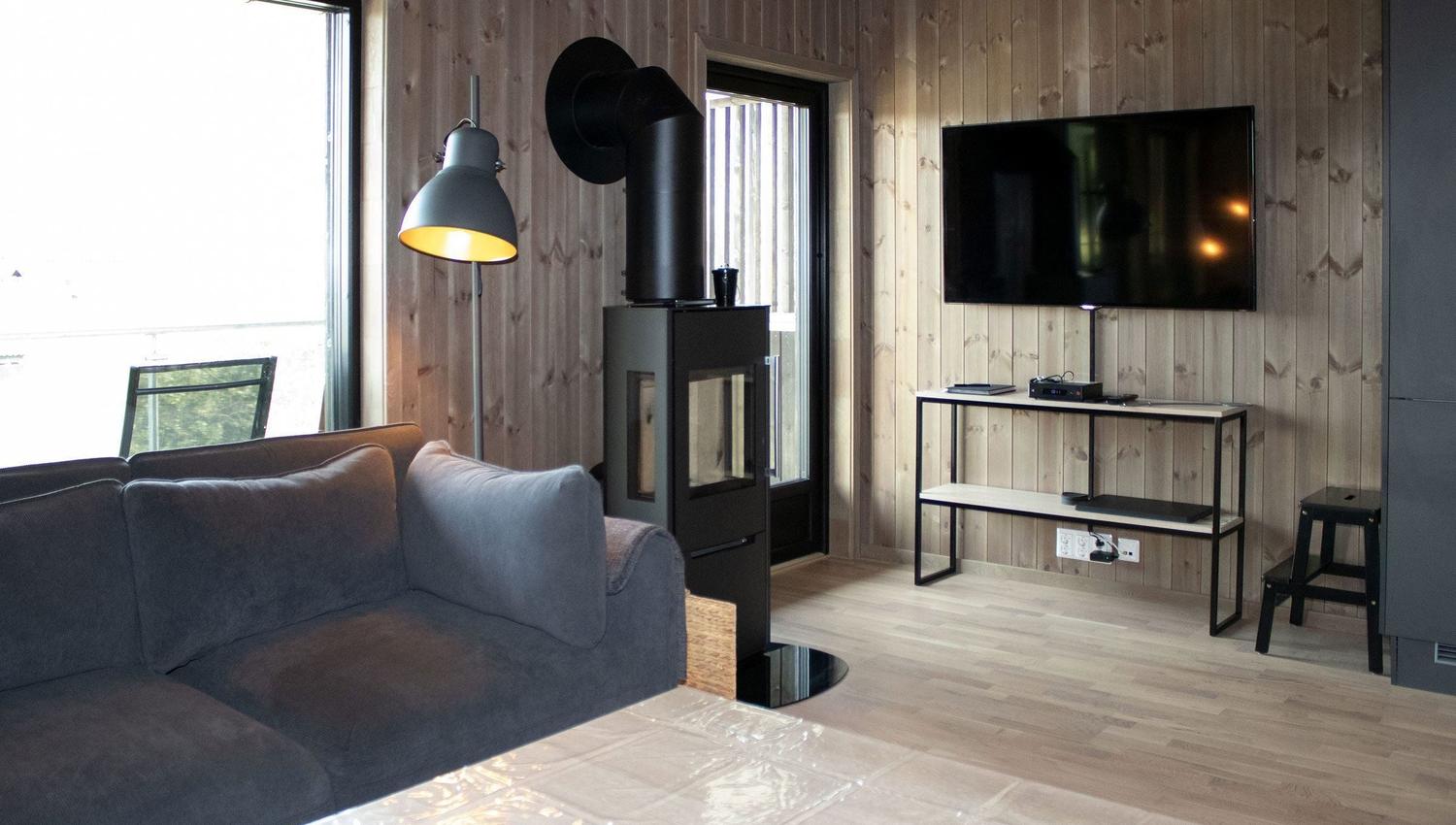 Ein Wohnzimmer mit Fernseher und Sofa.