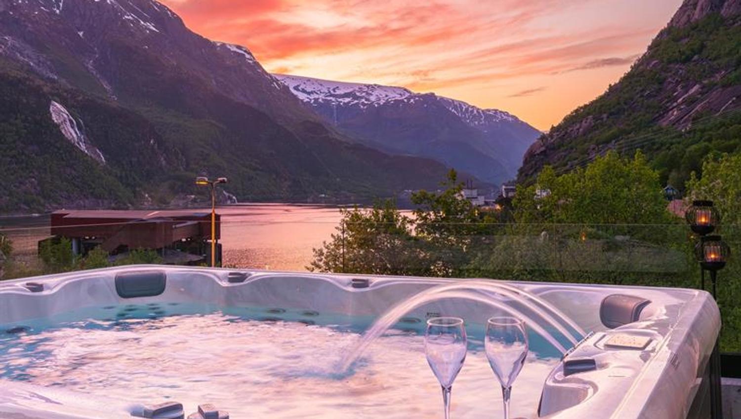 Jacuzzi at Tyssedal Hotel with fjord view at sunset.