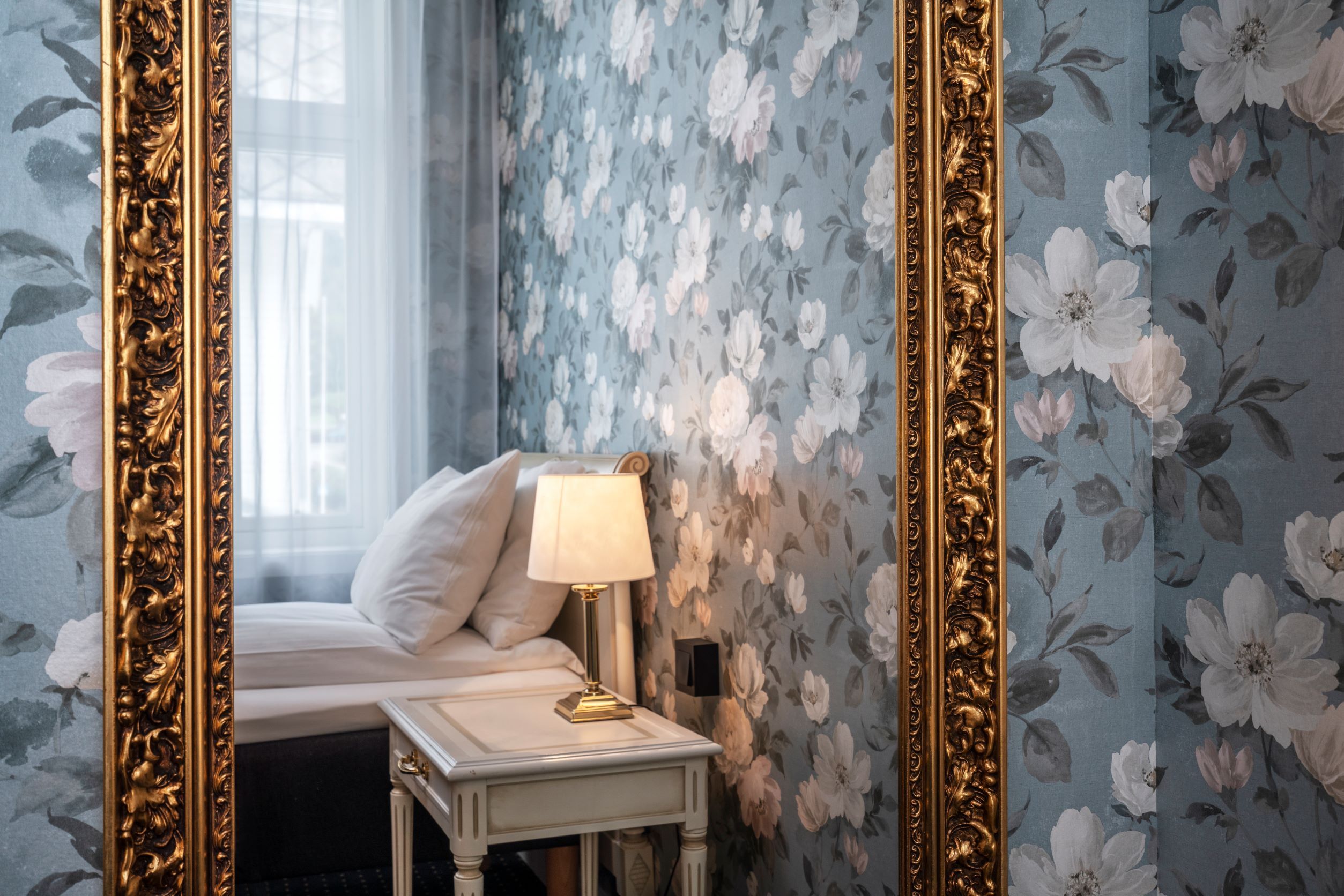 Stylish details at Thon Hotel Sandven – a classic gold-framed mirror reflecting the elegant decor.