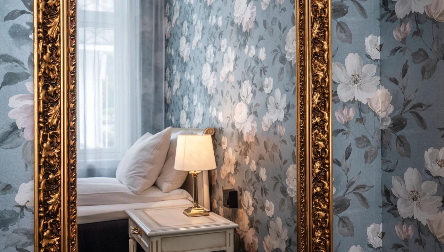 Stylish details at Thon Hotel Sandven – a classic gold-framed mirror reflecting the elegant decor.