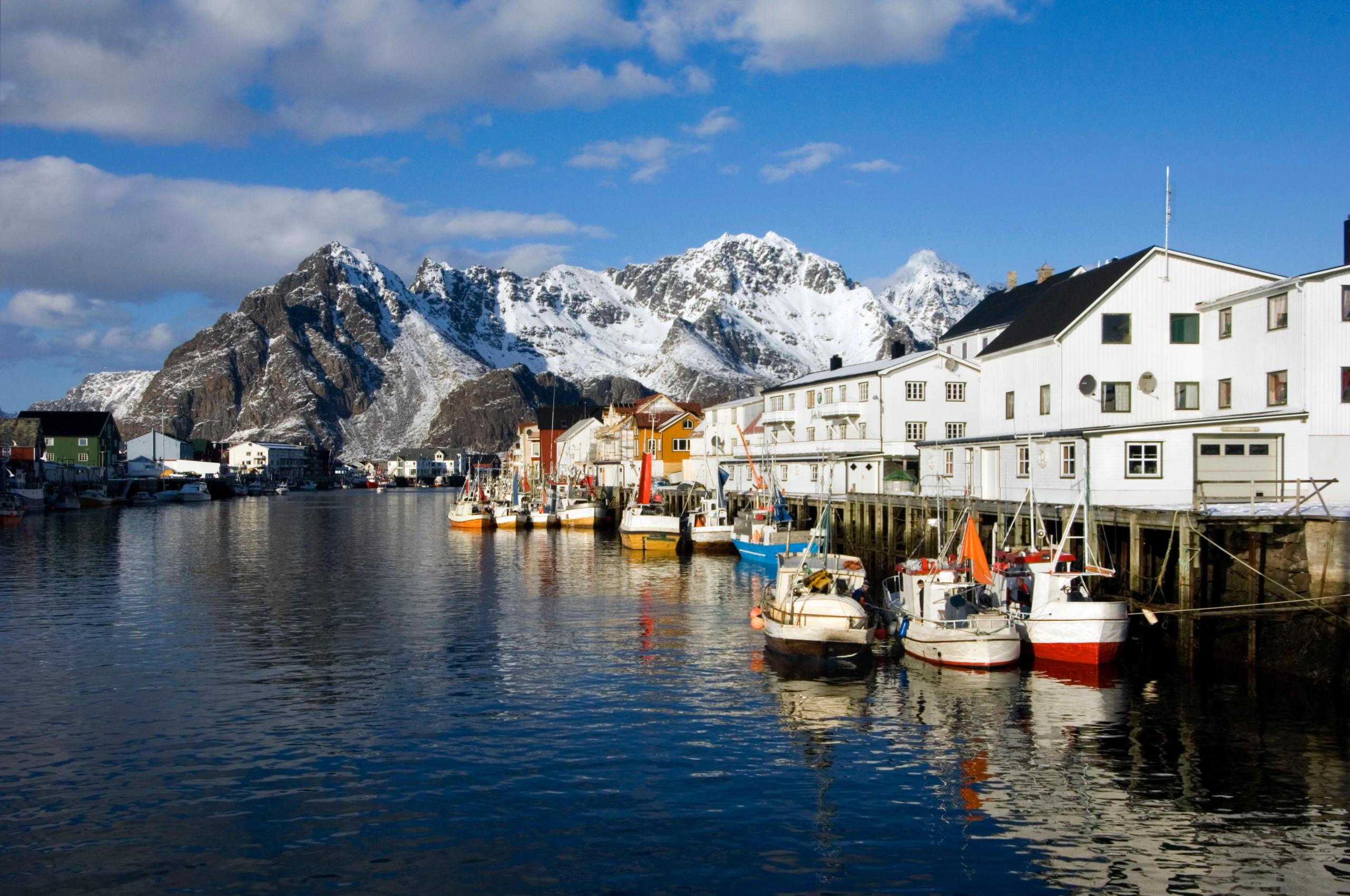 The fishing village Henningsvær with snow capped mountains in the back