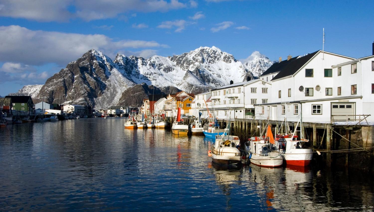 The fishing village Henningsvær with snow capped mountains in the back
