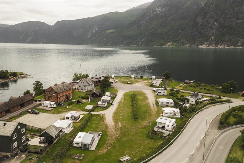 A drone photo og the campground with the fjord and mountains in the background