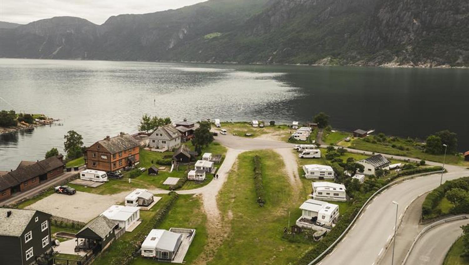 A drone photo og the campground with the fjord and mountains in the background