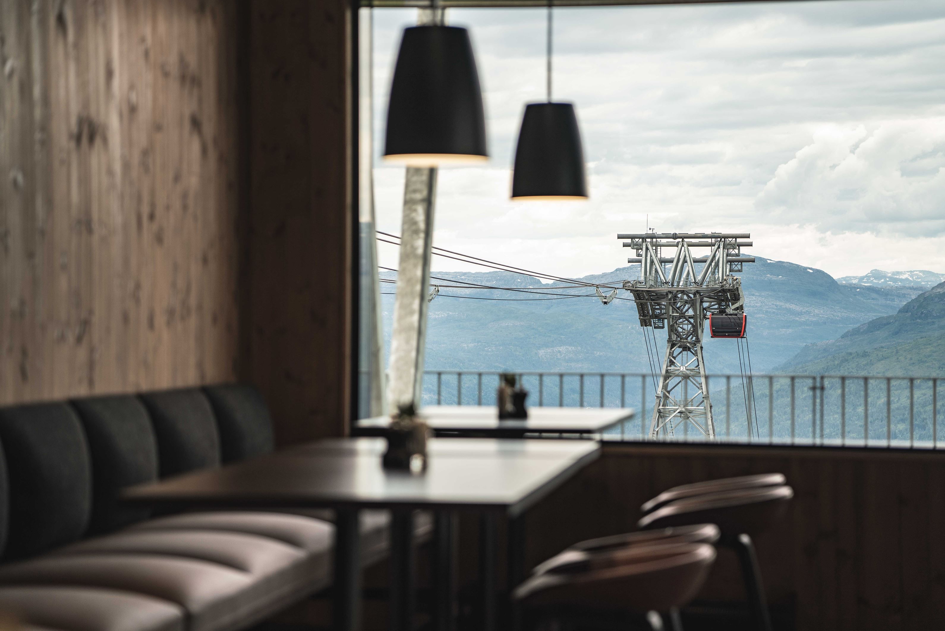 The inside of the restaurant at mount Hangur, with views of the gondola and the mountains. 