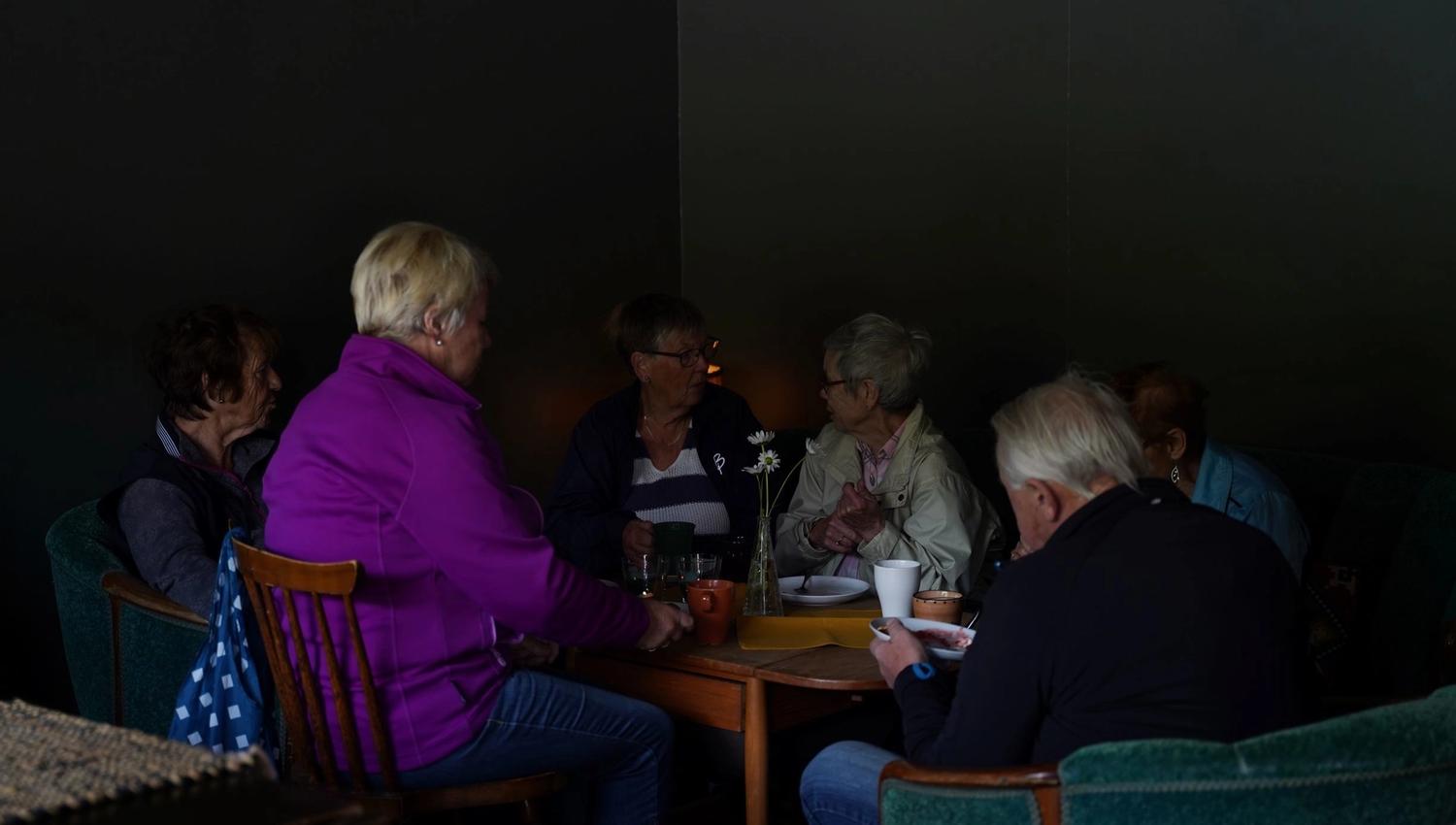 En gjeng som hygger seg rundt et bord på flattbrødbakeriet