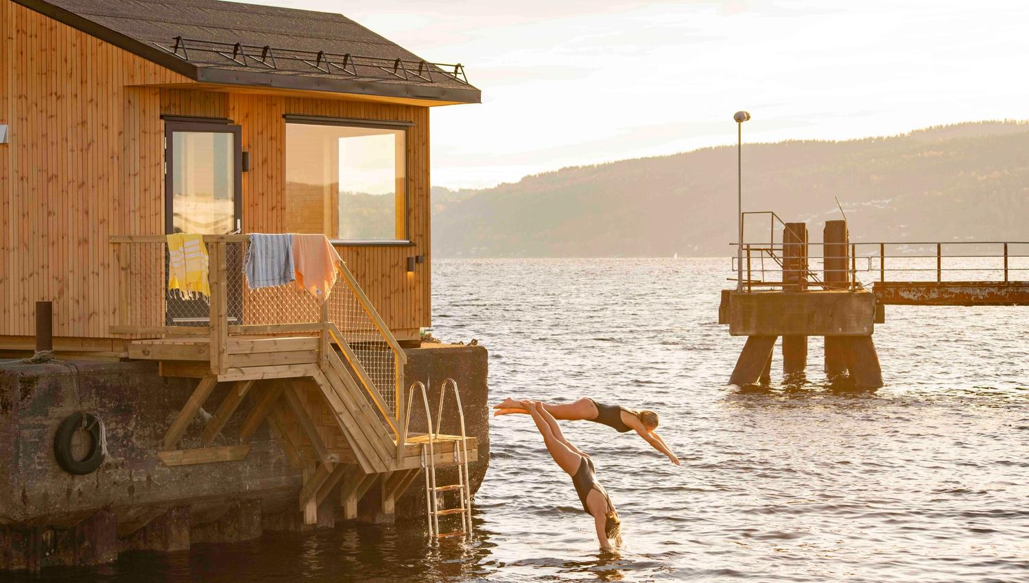 To damer som hopper fra brygga på Drøbak badstue