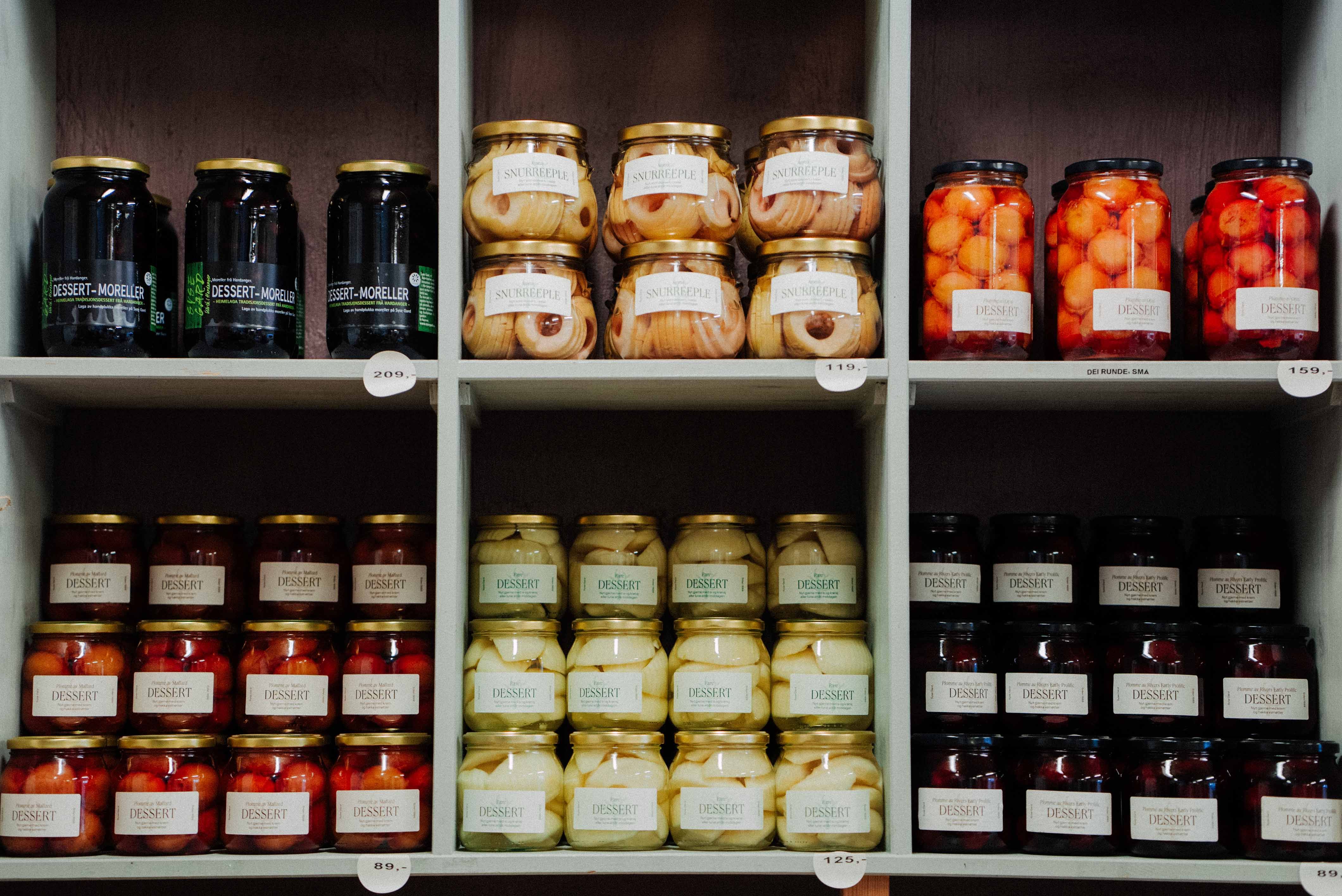 Shelf with preserved fruits from Syse Gard, ready for sale in the farm shop.
