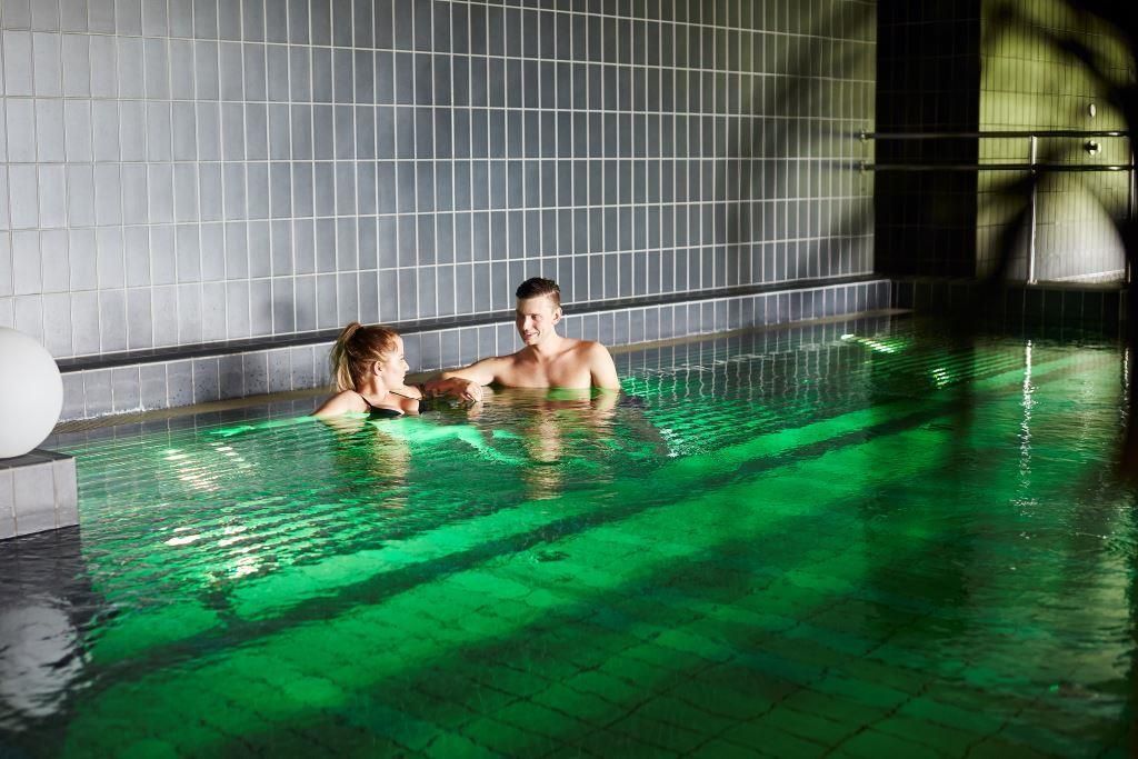 Two people in a pool in spa area 