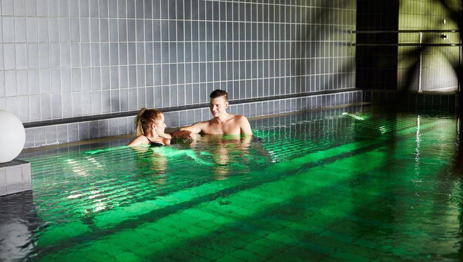 Two people in a pool in spa area