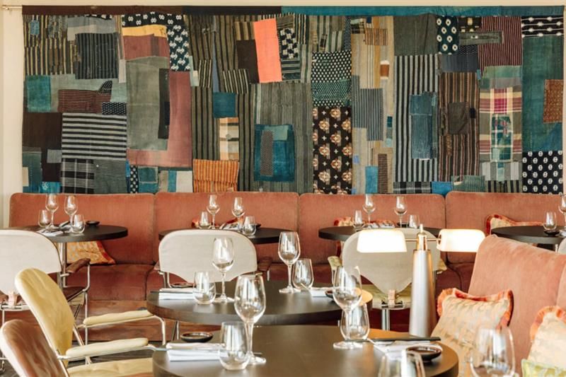 Red seating section with tables set for dining, wall decorations in the background.