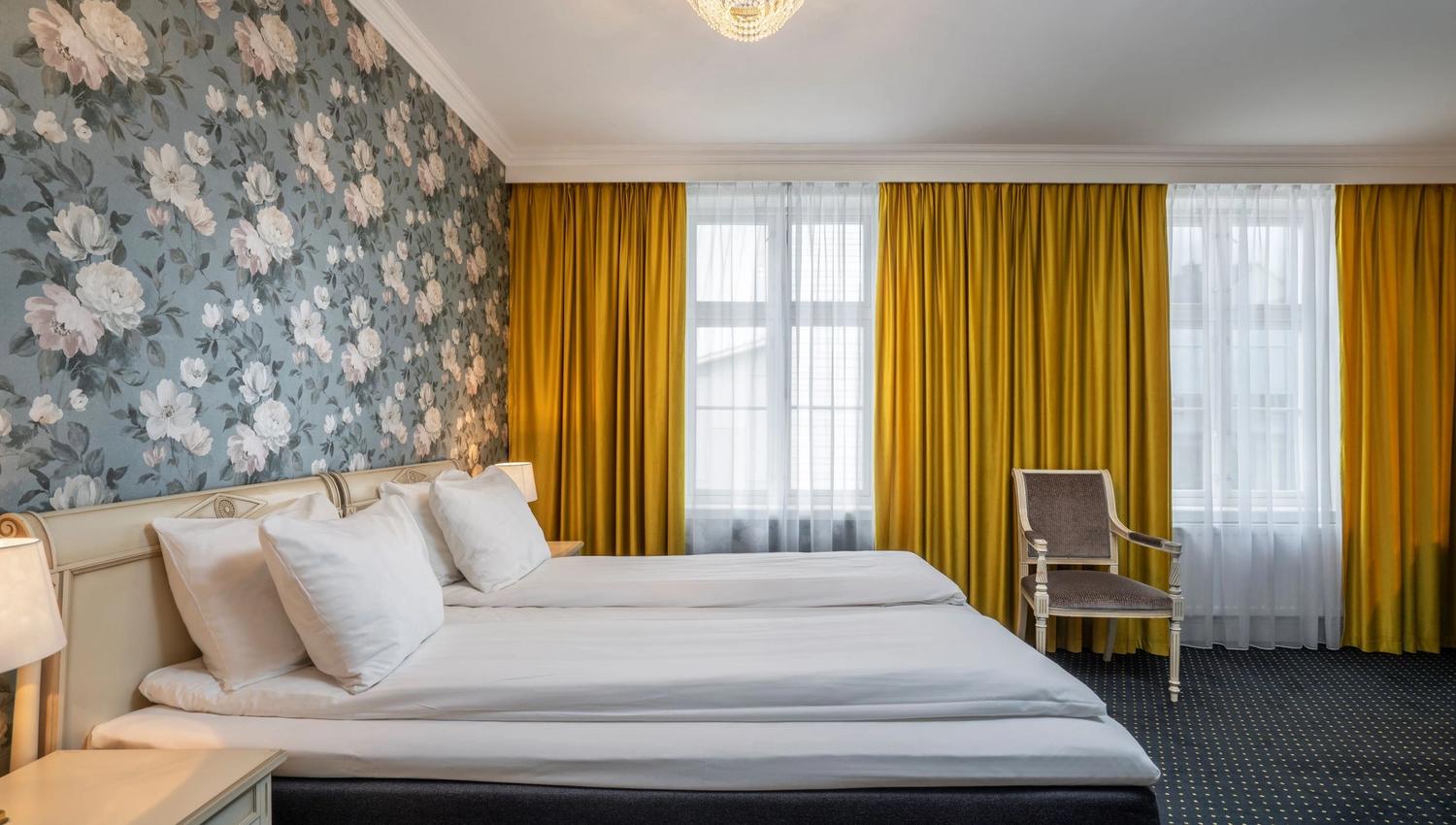 Bright and spacious hotel room at Thon Hotel Sandven, featuring exclusive decor and charming details.