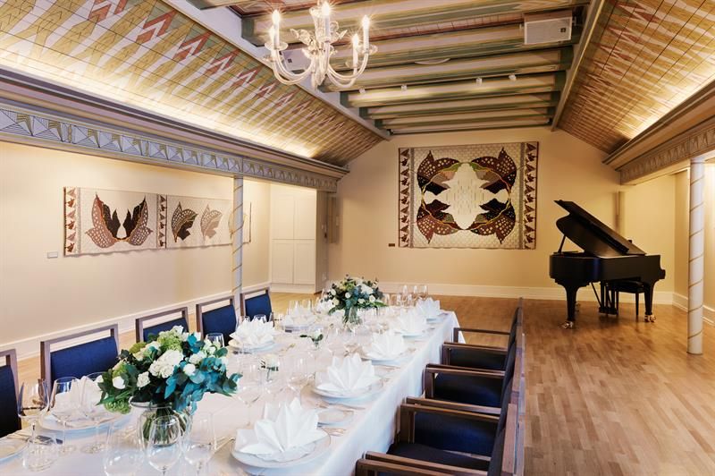 Long table set for dinner, grand piano in the background. Photo