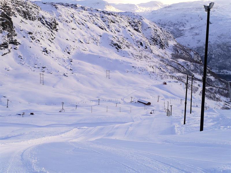 Frisch präparierte Pisten im Røldal Skigebiet, umgeben von steilen Bergen und Winterlandschaft.