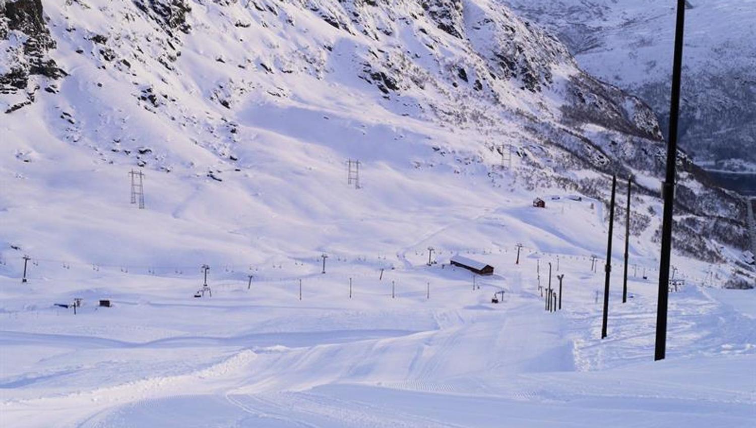 Frisch präparierte Pisten im Røldal Skigebiet, umgeben von steilen Bergen und Winterlandschaft.