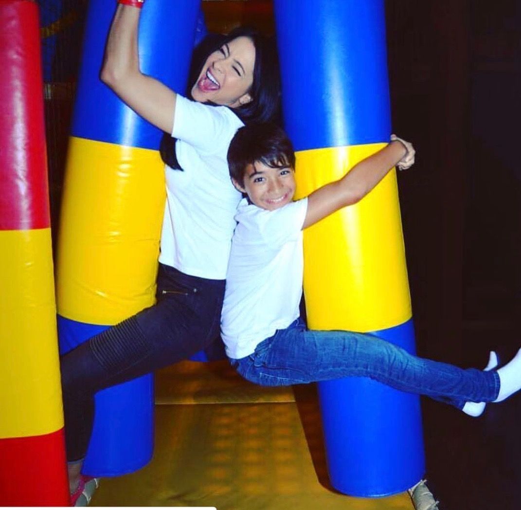 Two children hanging out playing in a playground