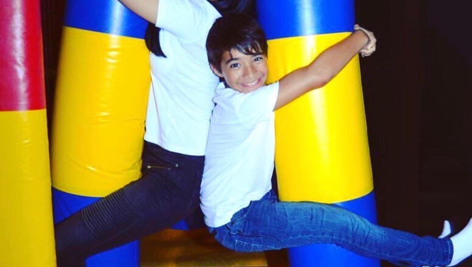 Two children hanging out playing in a playground