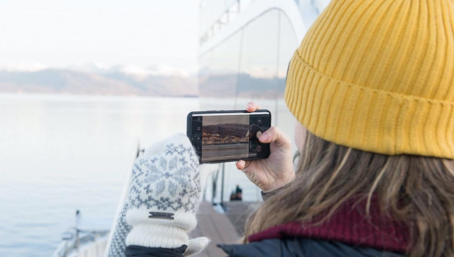 gjest som fanger omgivelsene med telefonen