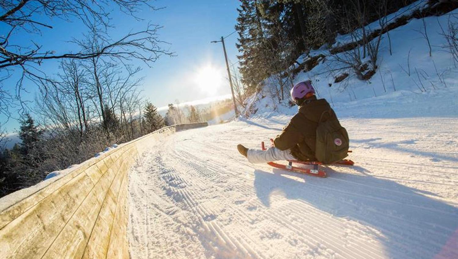 A child sledding down a snow-covered hill.