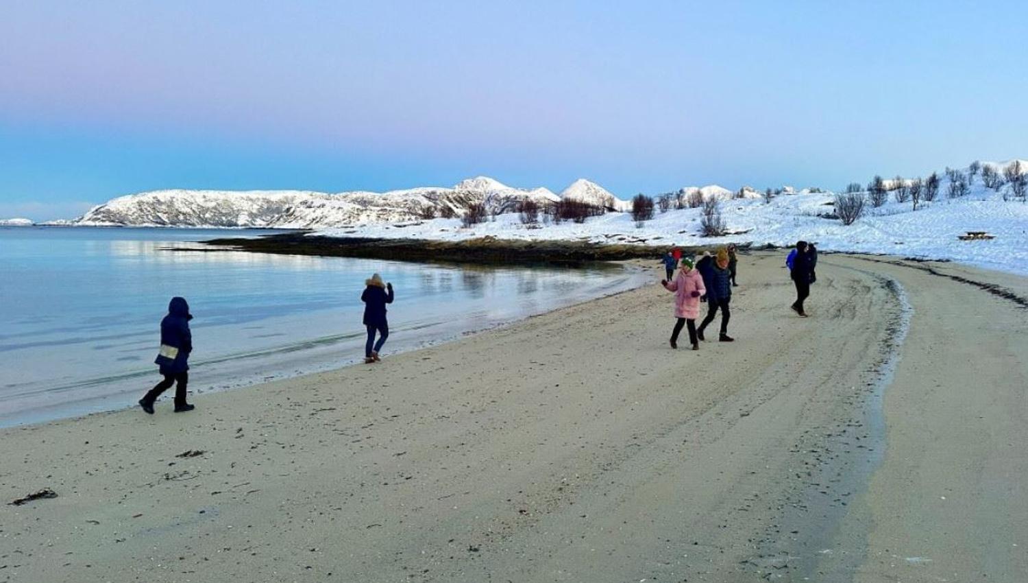 Guests walk along the beach on Sommarøy