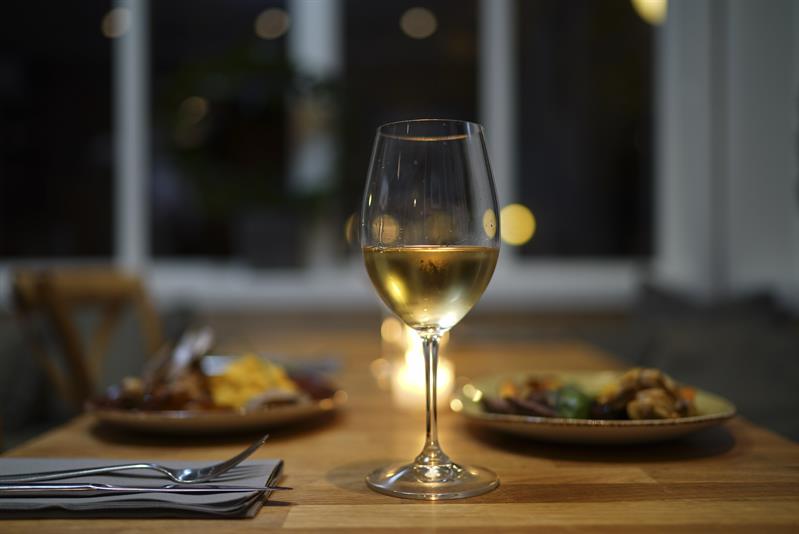 Wine in a glass and food on a plate.