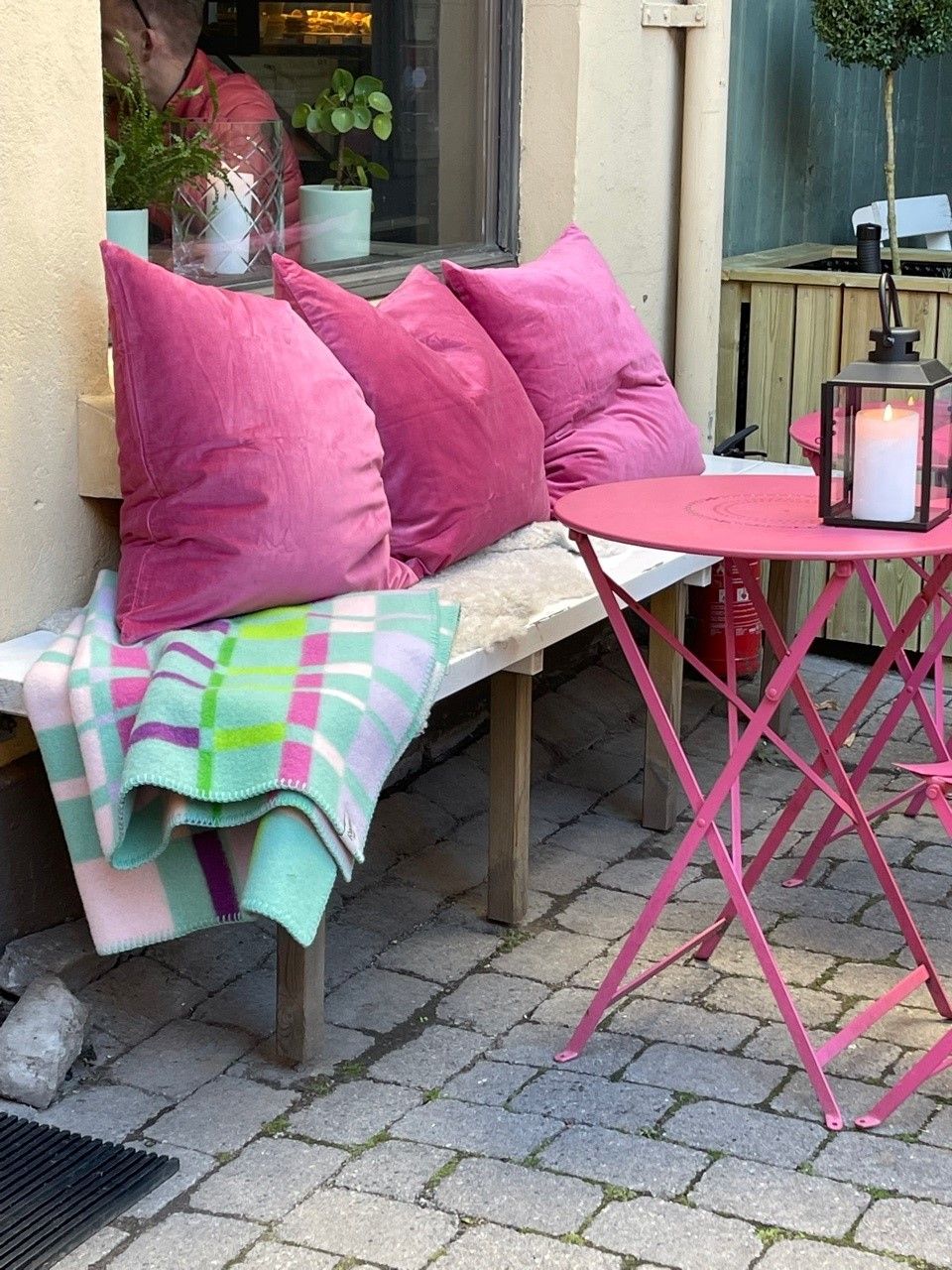 Bench with pink table, pink cushions and blanket