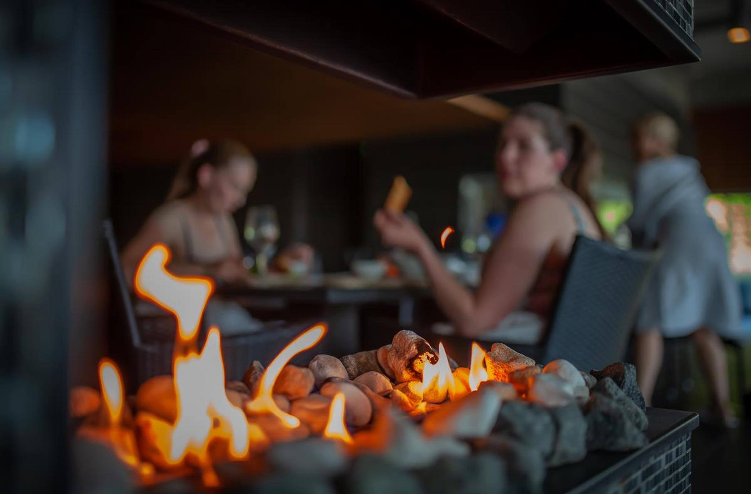 Personer spiser i spa-avdeling. levende flamme