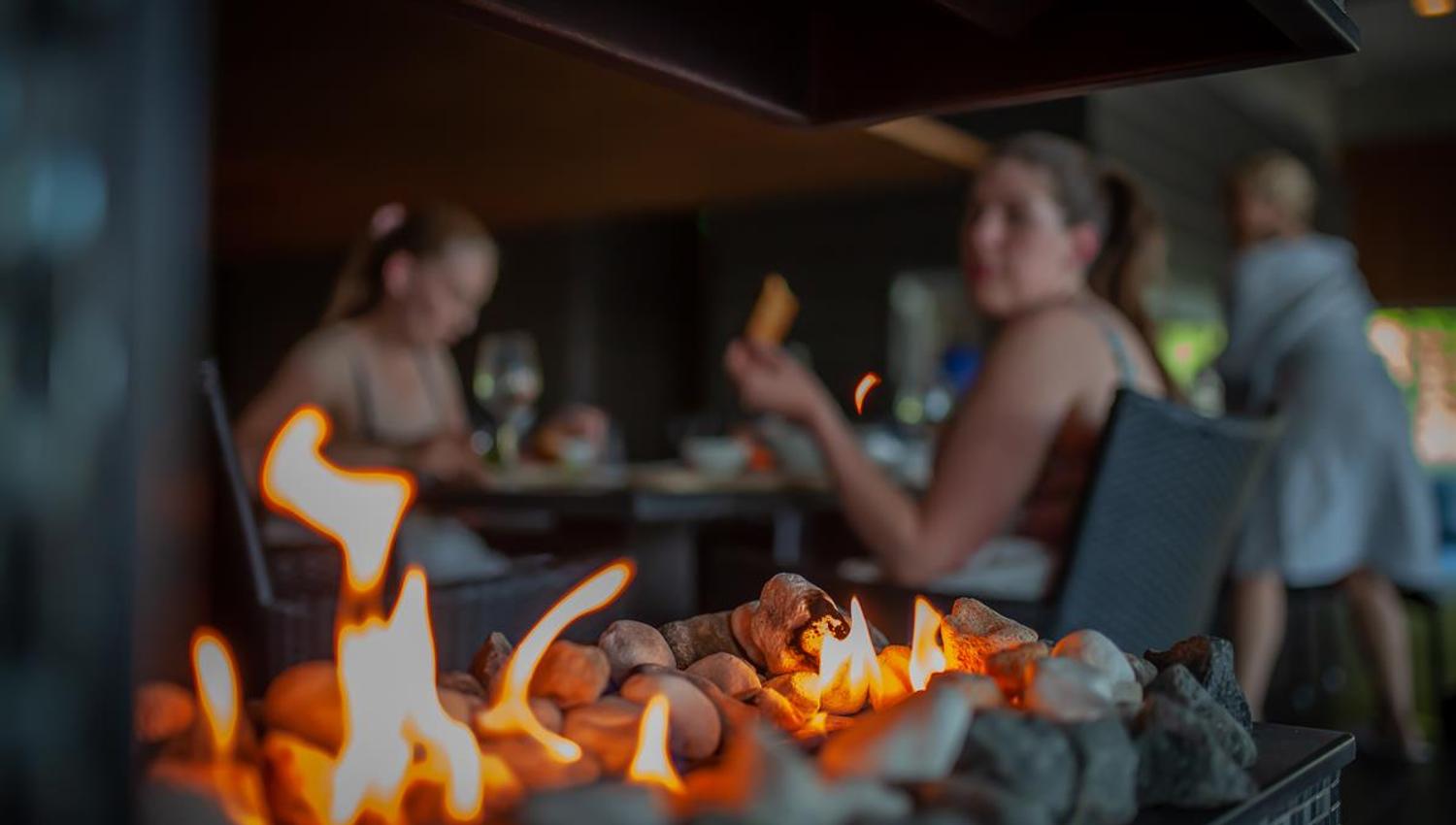 People eating in spa-area. Alive flame