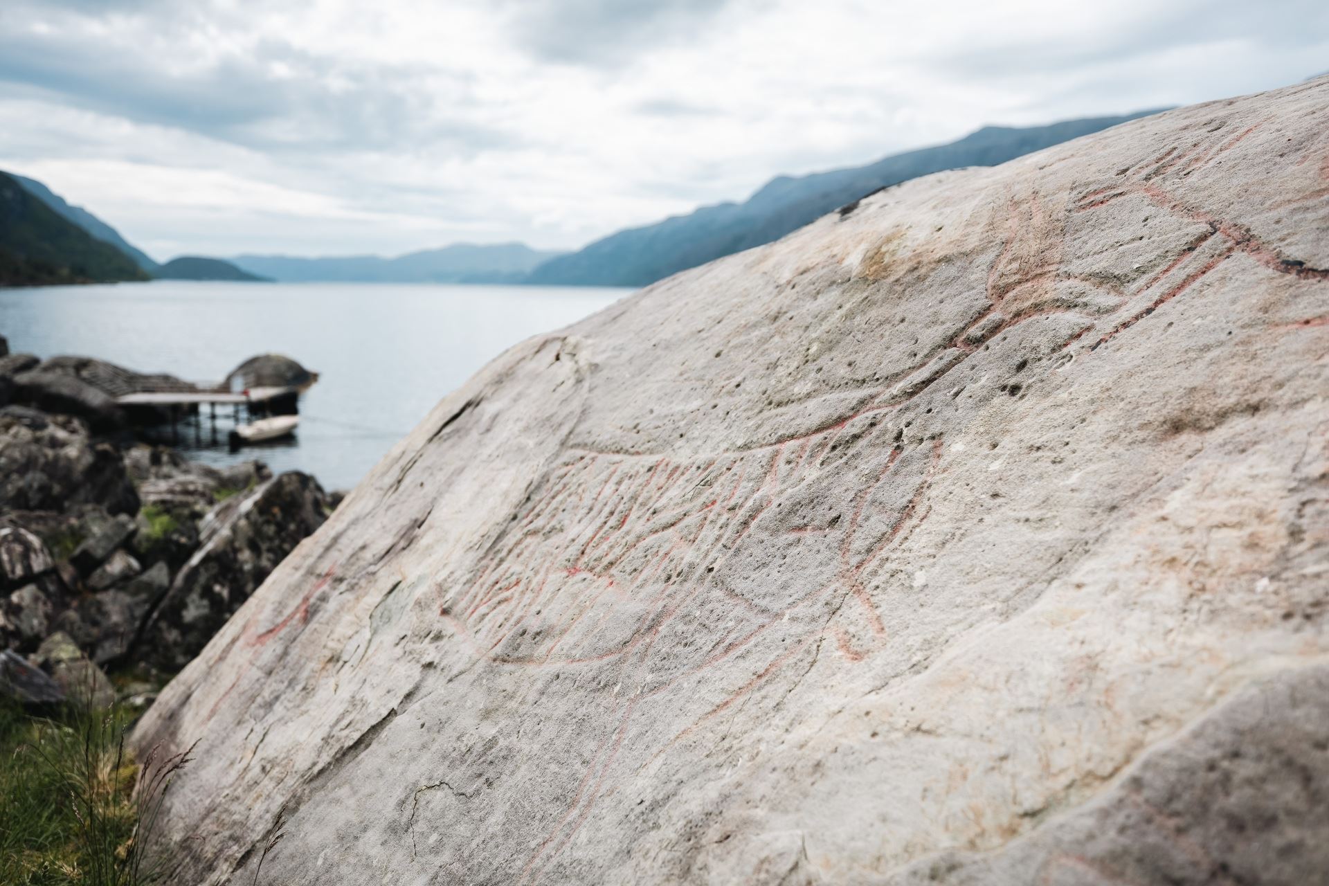 Close-up of ancient rock carvings on a smooth rock surface in Vingen.