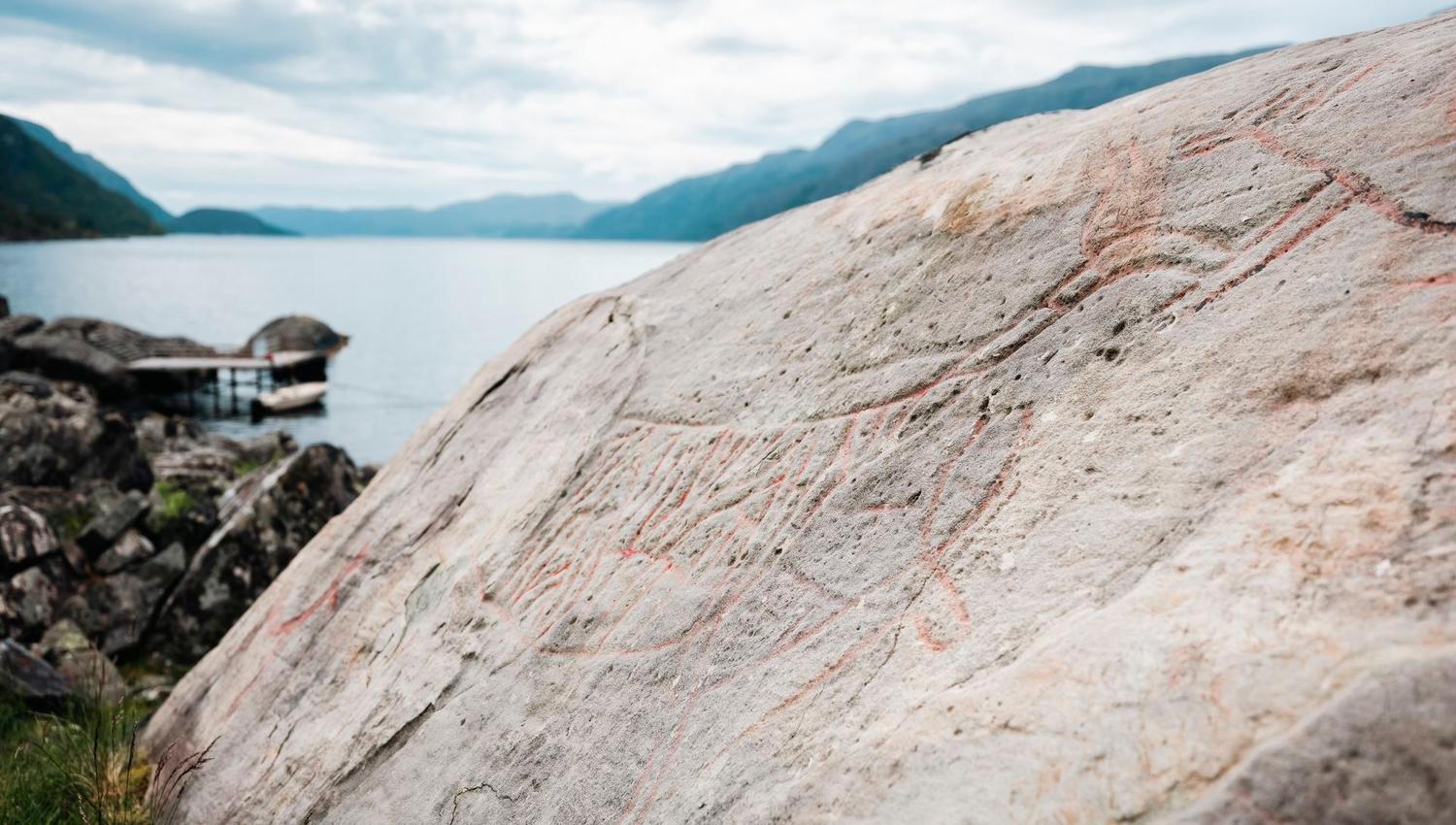 Close-up of ancient rock carvings on a smooth rock surface in Vingen.