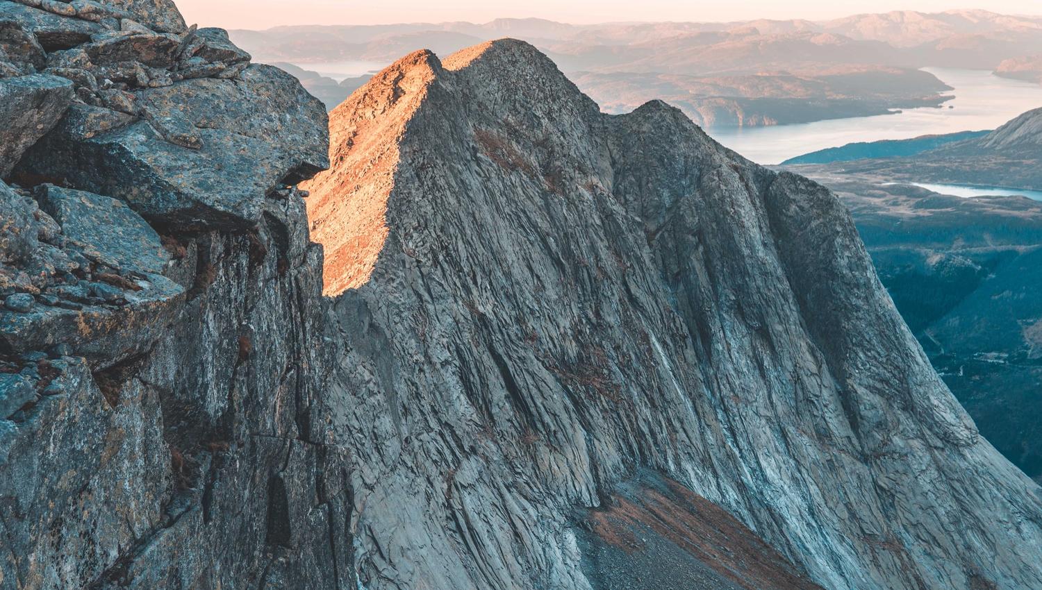 Steep mountain walls and dramatic rock formations on the Ulvanosa massif in Hardanger, captured from the trail towards Geitadalstinden and Høgetinden.