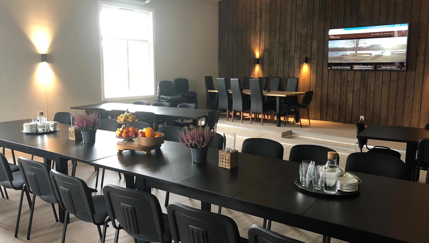 Langbord med stoler og en TV