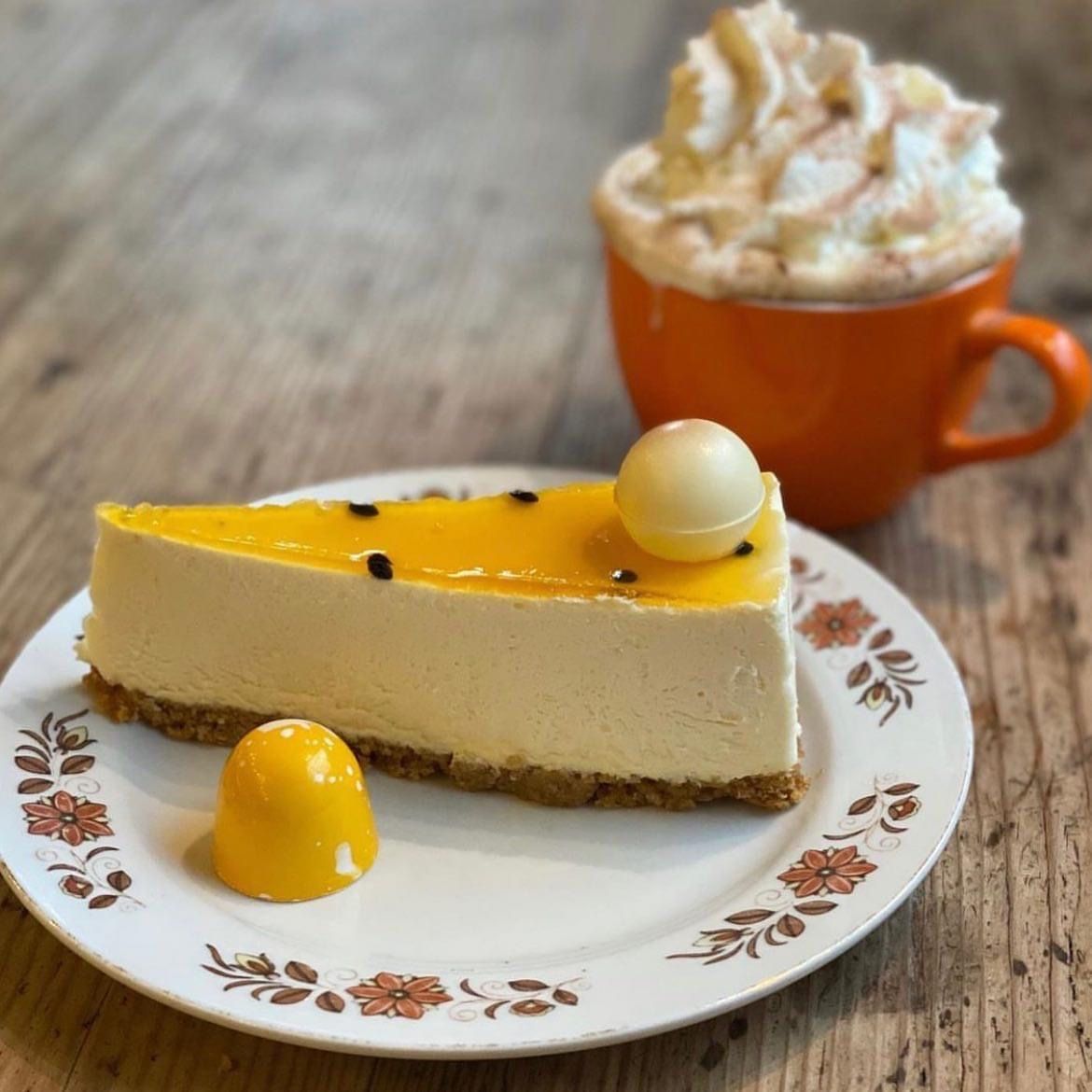 ostekake med gul gele lokk og en kopp kaffe i bakgrunnen