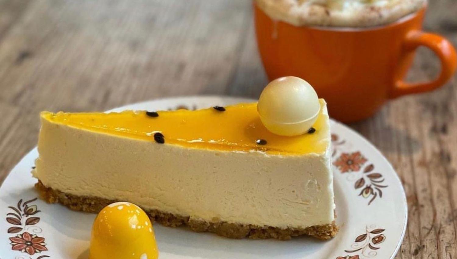 ostekake med gul gele lokk og en kopp kaffe i bakgrunnen