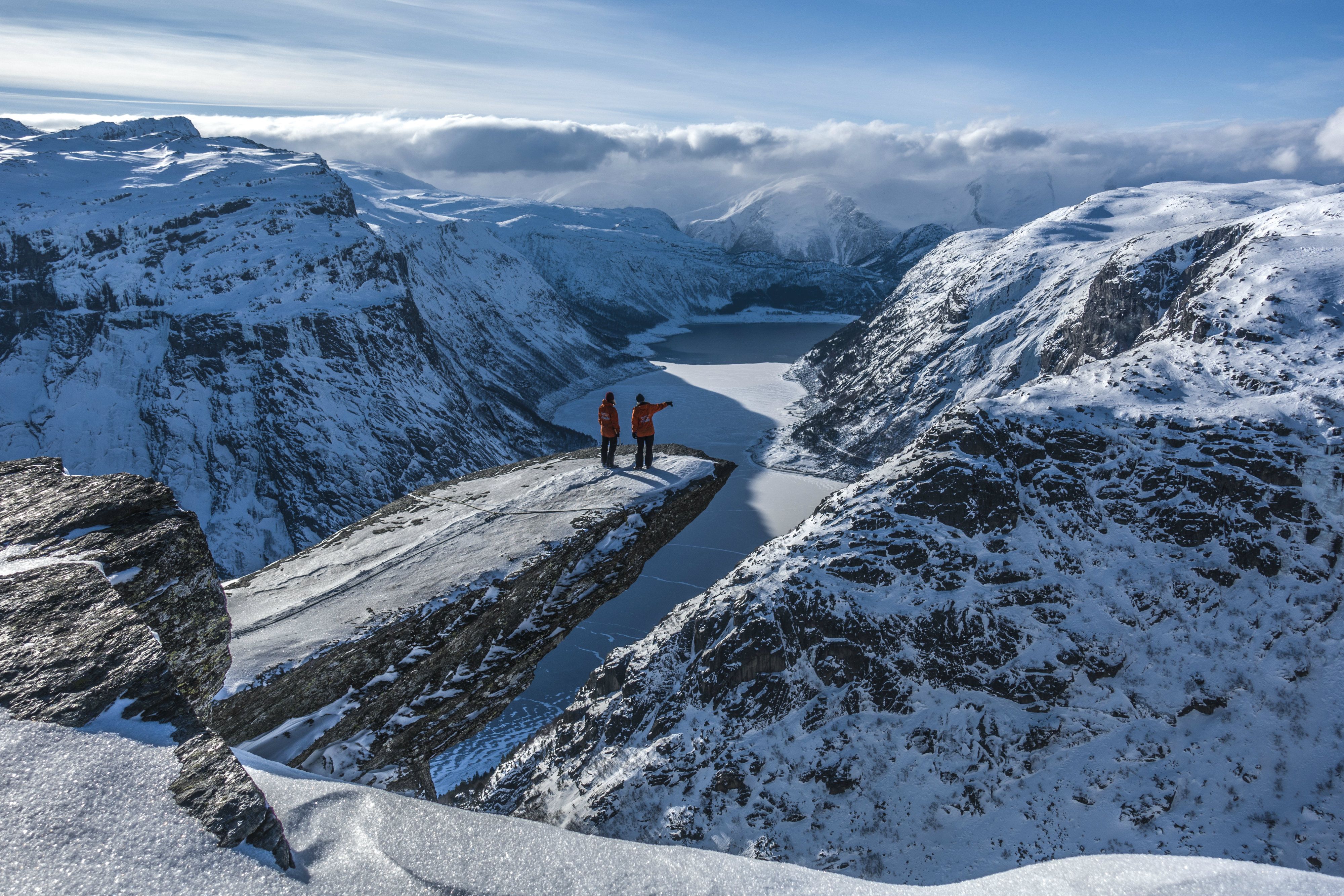 Two people at Trolltunga during winter. 