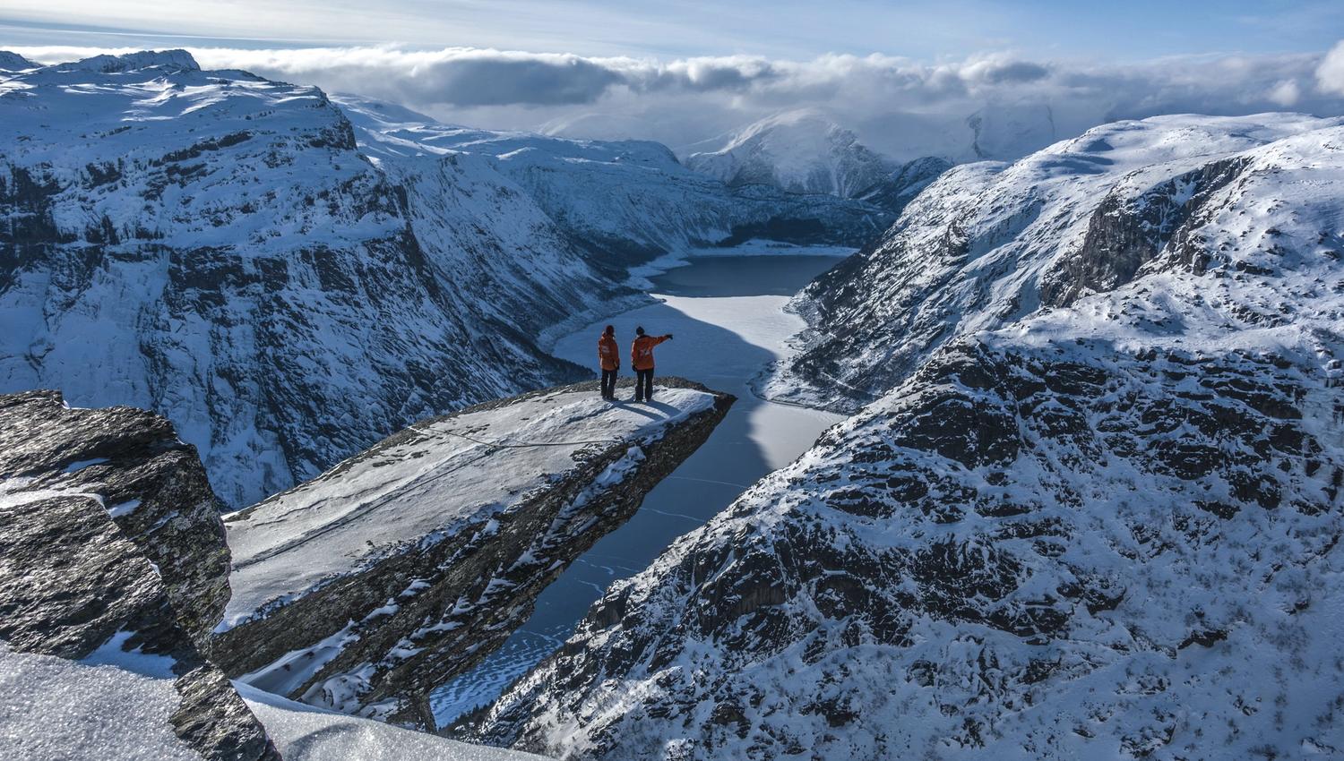 Two people at Trolltunga during winter.