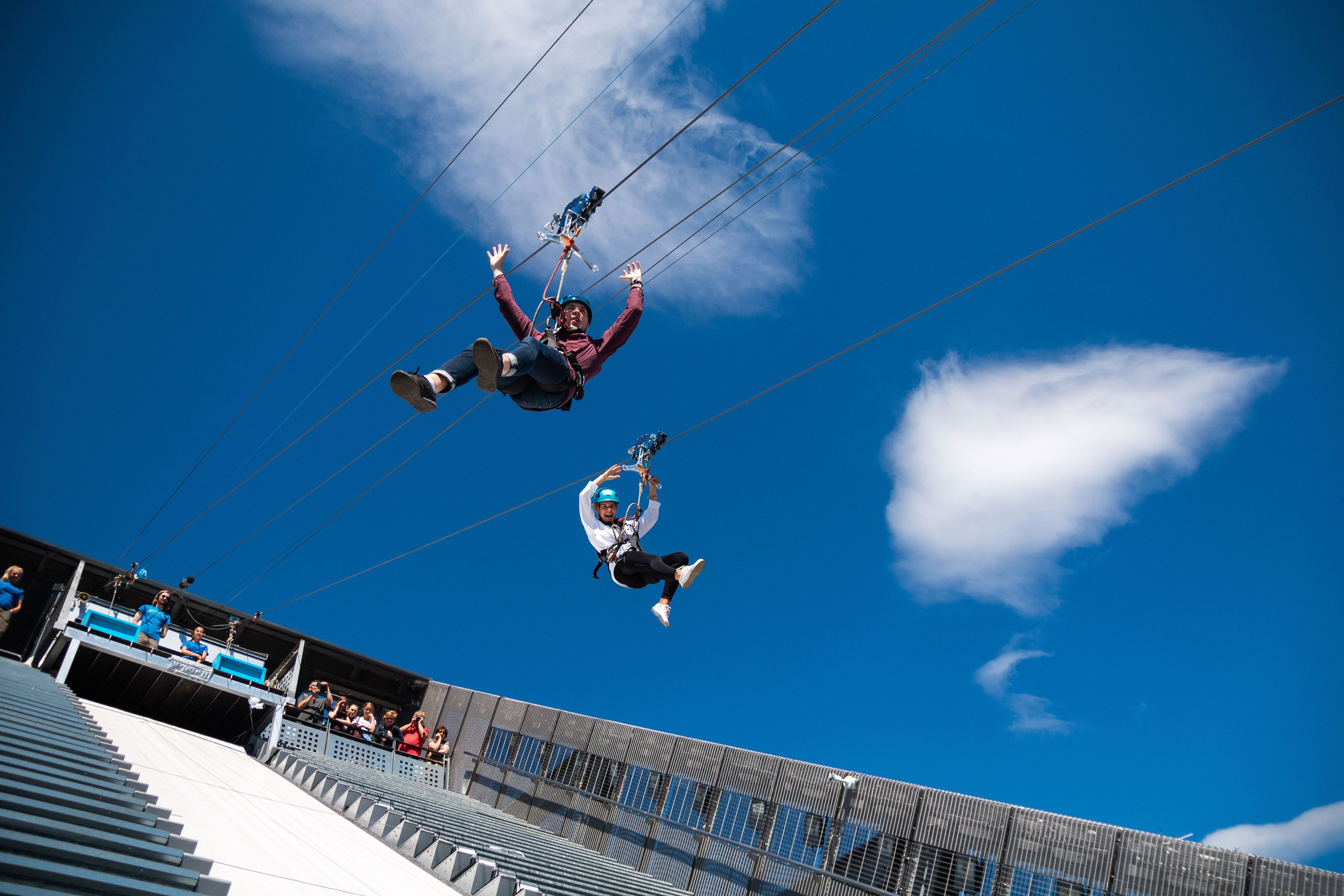 Two people ziplining down Holmenkollen Ski Jump.