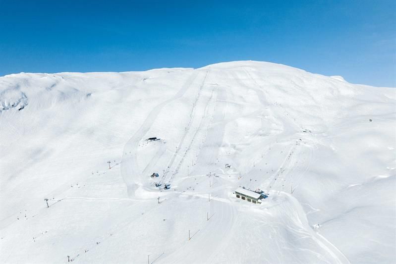 Präparierte Skipisten und Lifte im Røldal Skigebiet unter blauem Himmel und funkelndem Schnee.
