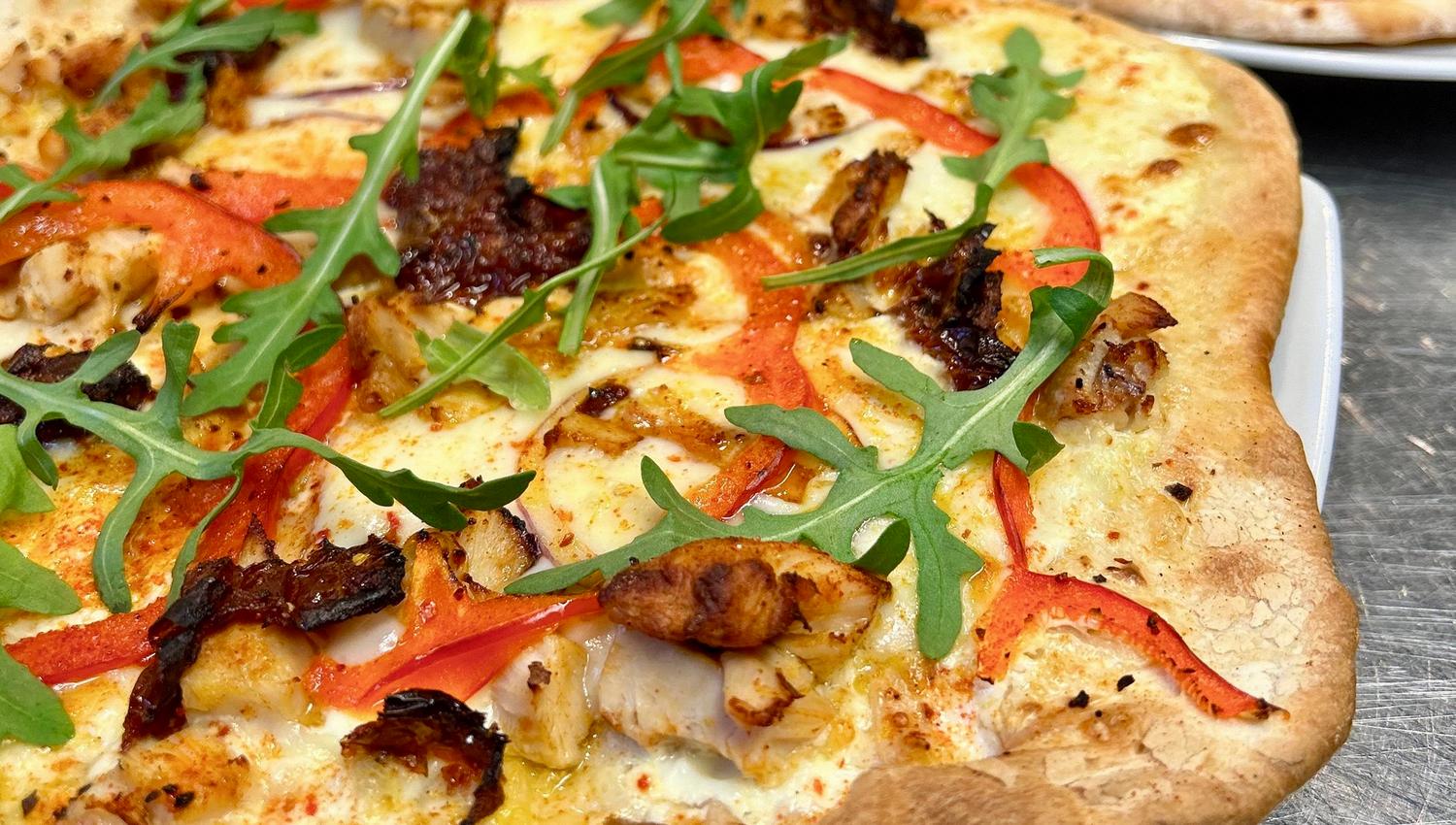 Pizza with ruccola, peppers and cheese