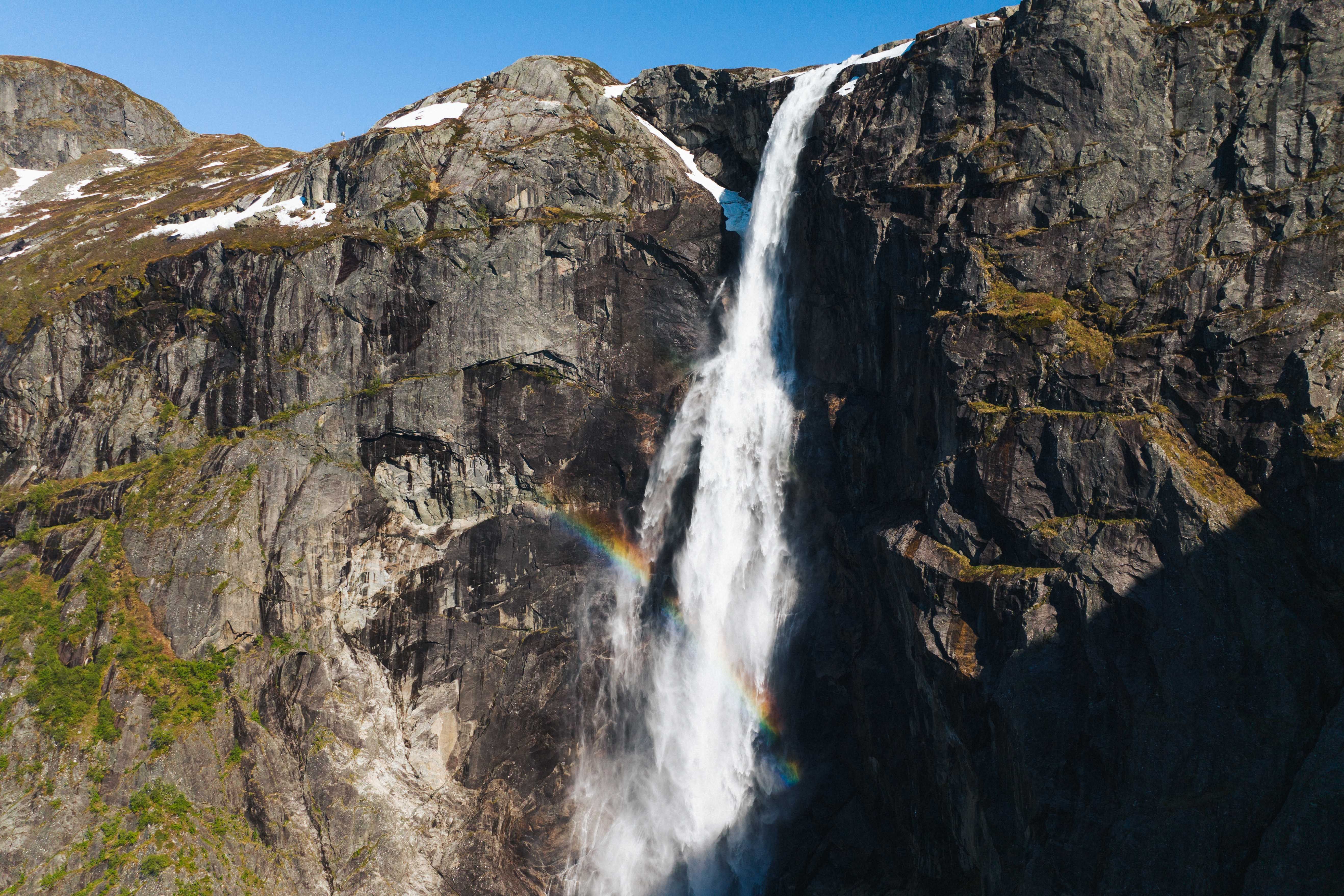 The Skytjefossen waterfall with a rainbow in front.